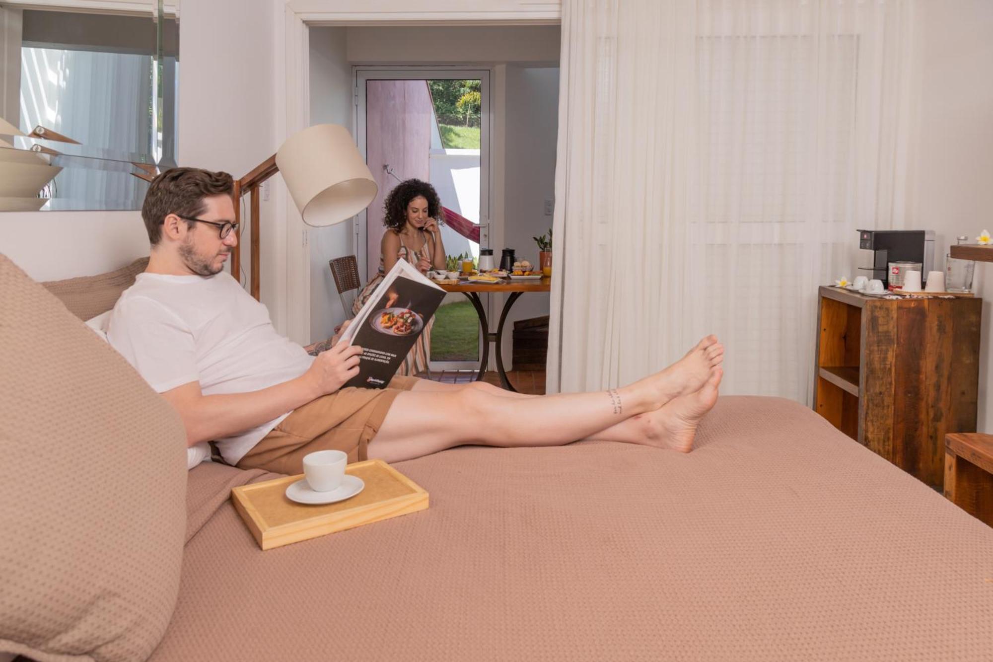 Hotel Boutique Frangipani Brotas Extérieur photo A man reading a book while a woman cooks